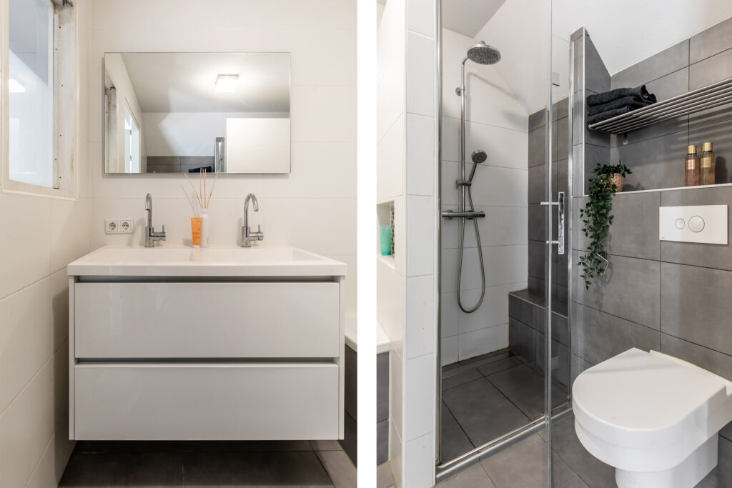 Modern bathroom with double sink, shower, and toilet