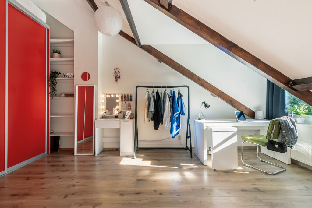 Modern attic bedroom with workstation and wardrobe.