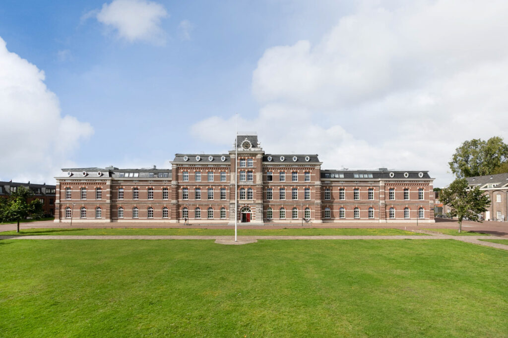 Historic brick building with expansive green lawn.
