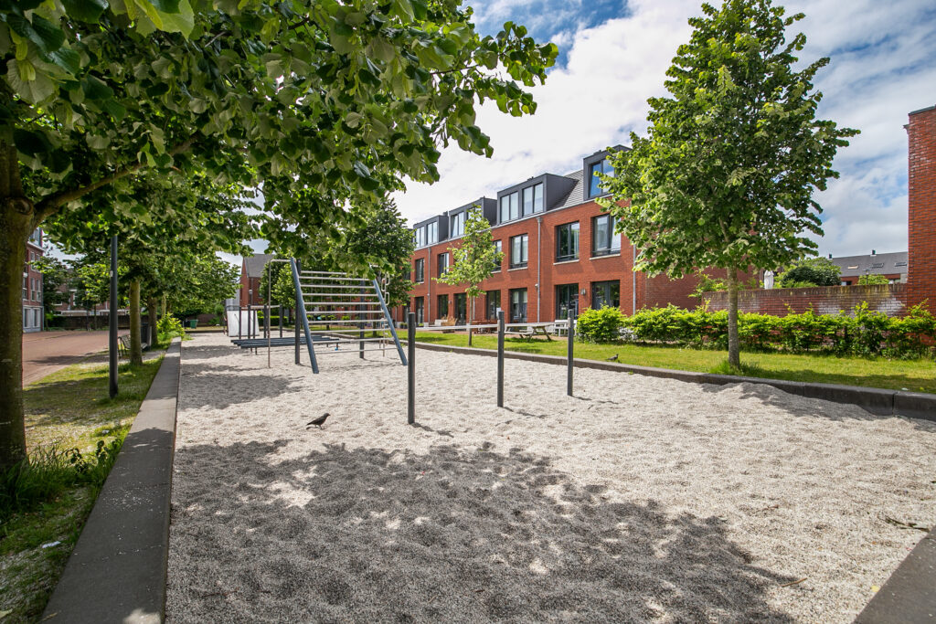 Playground with trees and brick buildings nearby