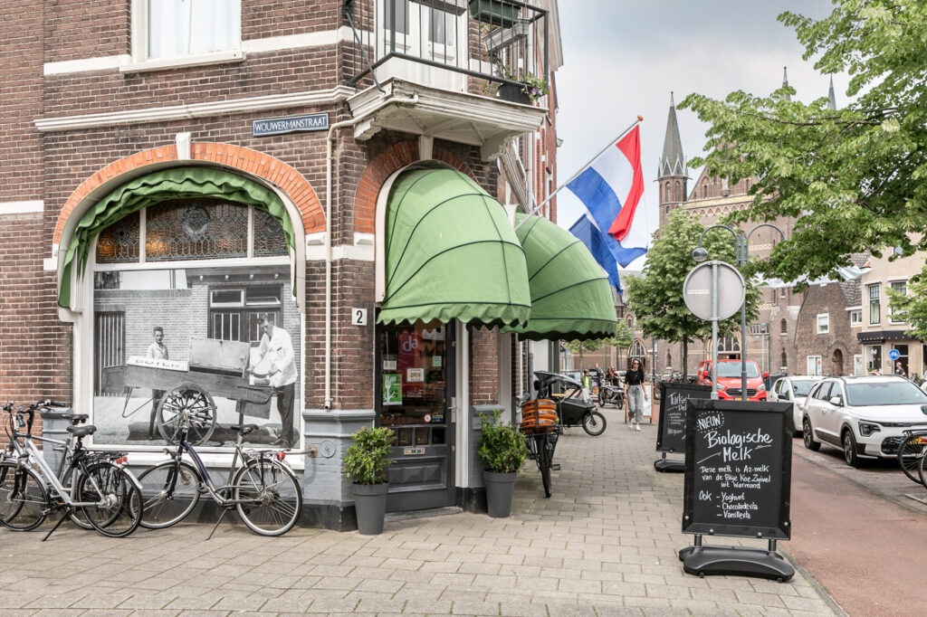Dutch street corner with bicycles and shop signs.