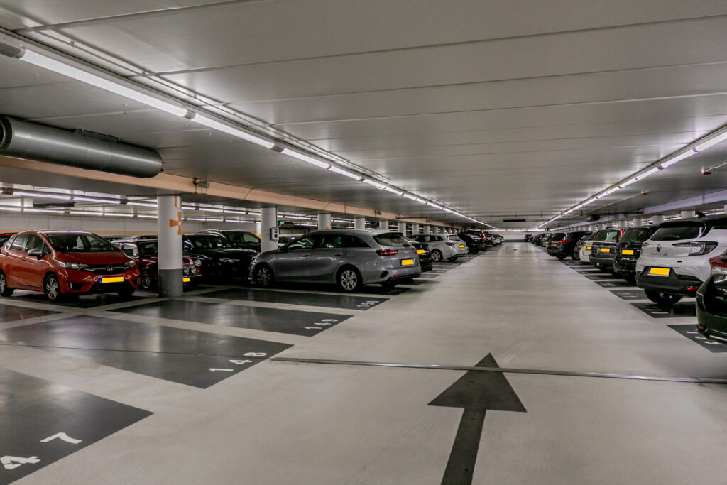 Spacious underground parking garage with parked cars.