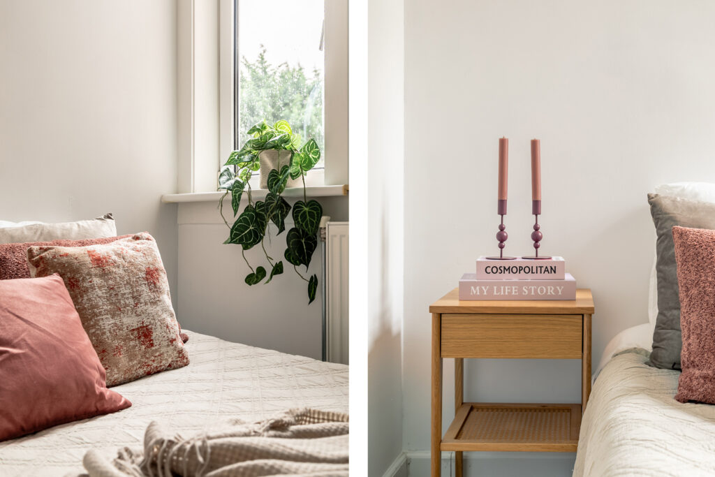 Cozy bedroom with pillows, plants, books, and candles.
