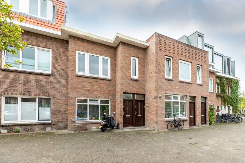 Dutch brick townhouse with bicycles outside.
