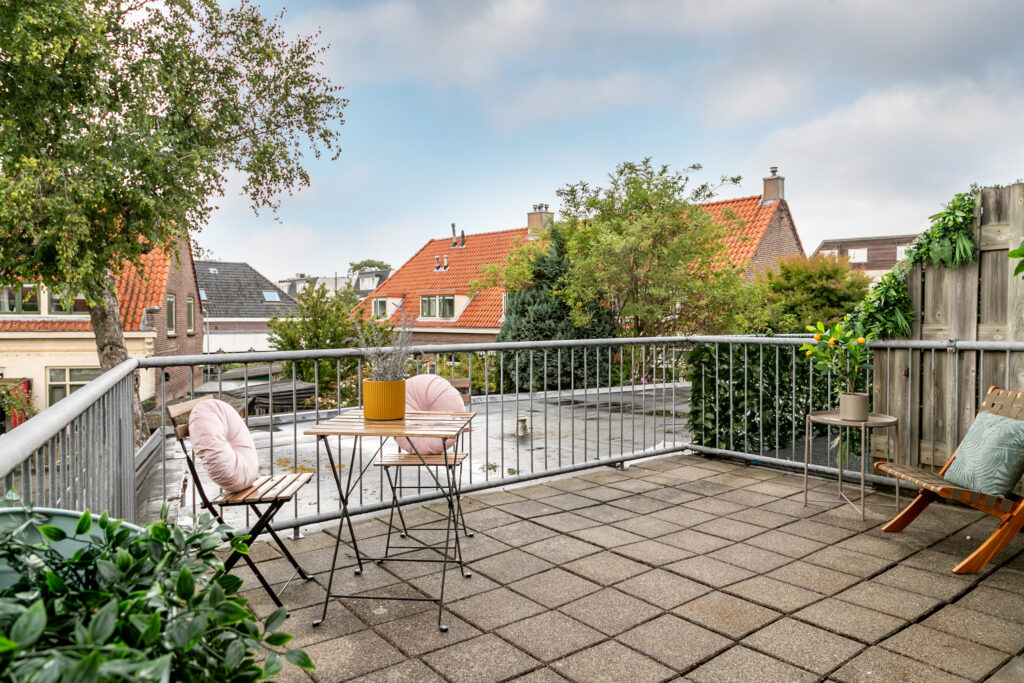 Cozy rooftop patio with table and chairs.