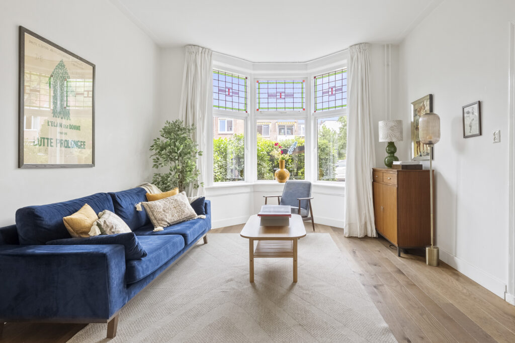 Bright living room with blue sofa and bay window.