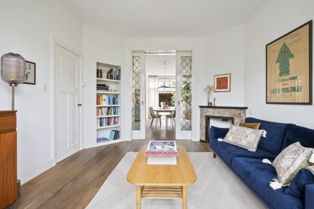 Cozy living room with blue sofa and bookshelves.