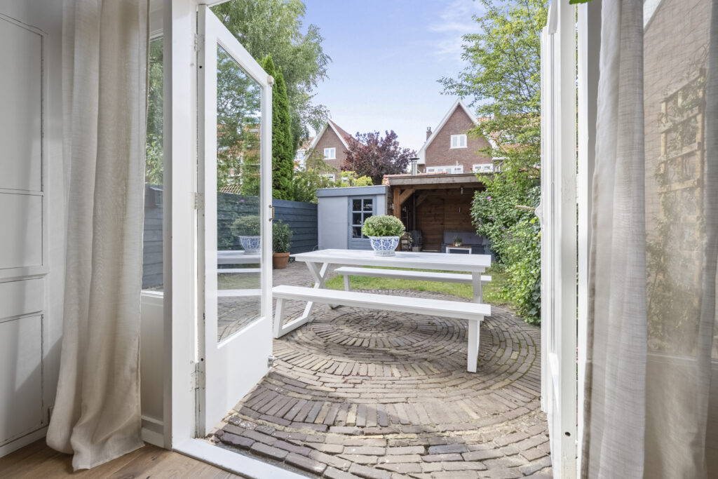 Open patio door to serene backyard space.