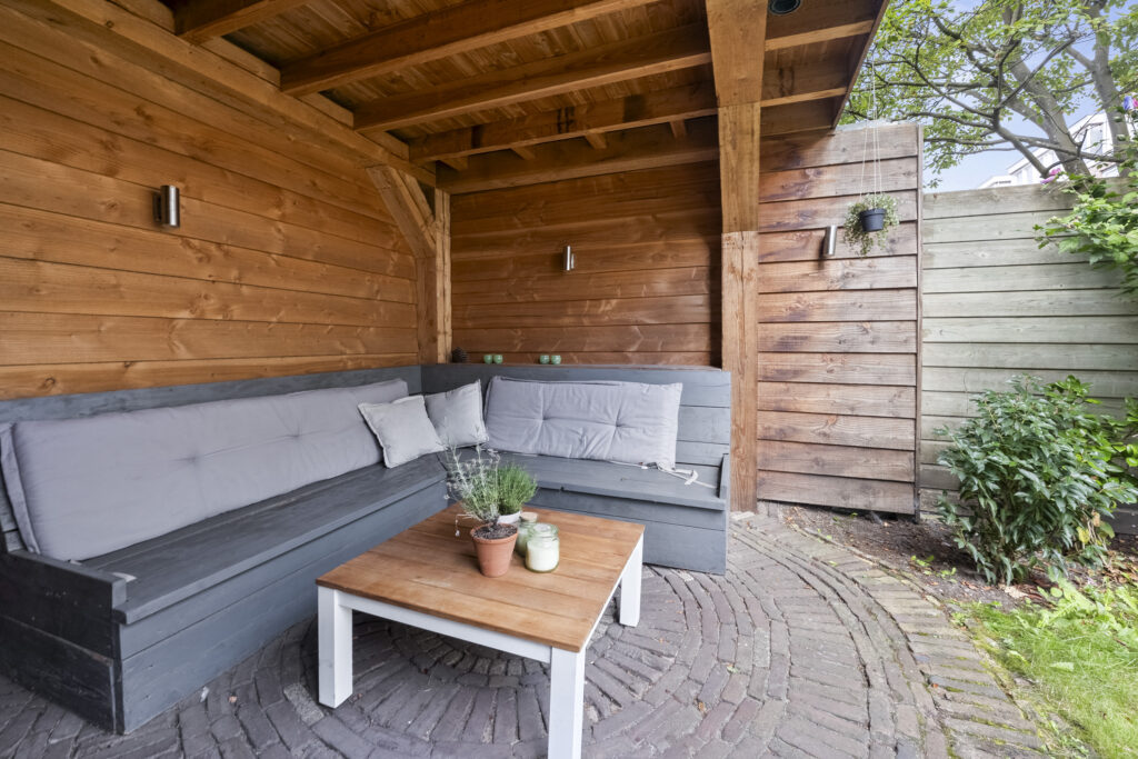 Cozy wooden patio with seating and table.