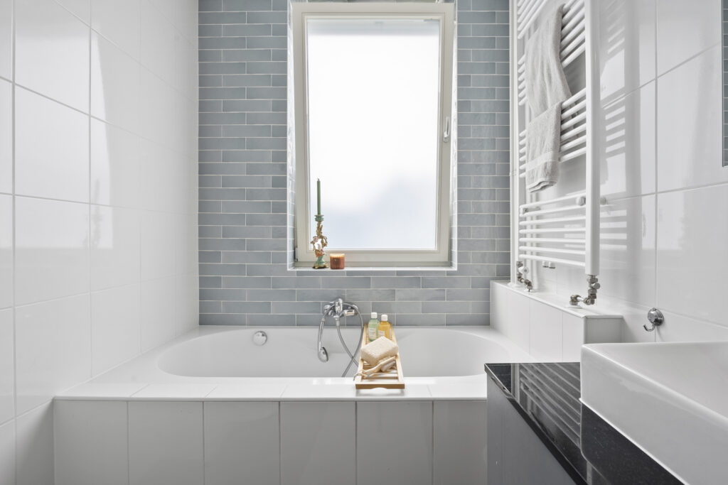 Modern bathroom with bathtub and window view.