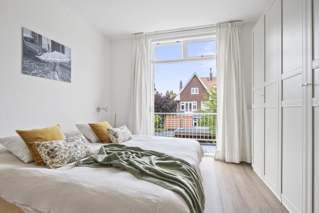 Bright bedroom with large window and cozy decor