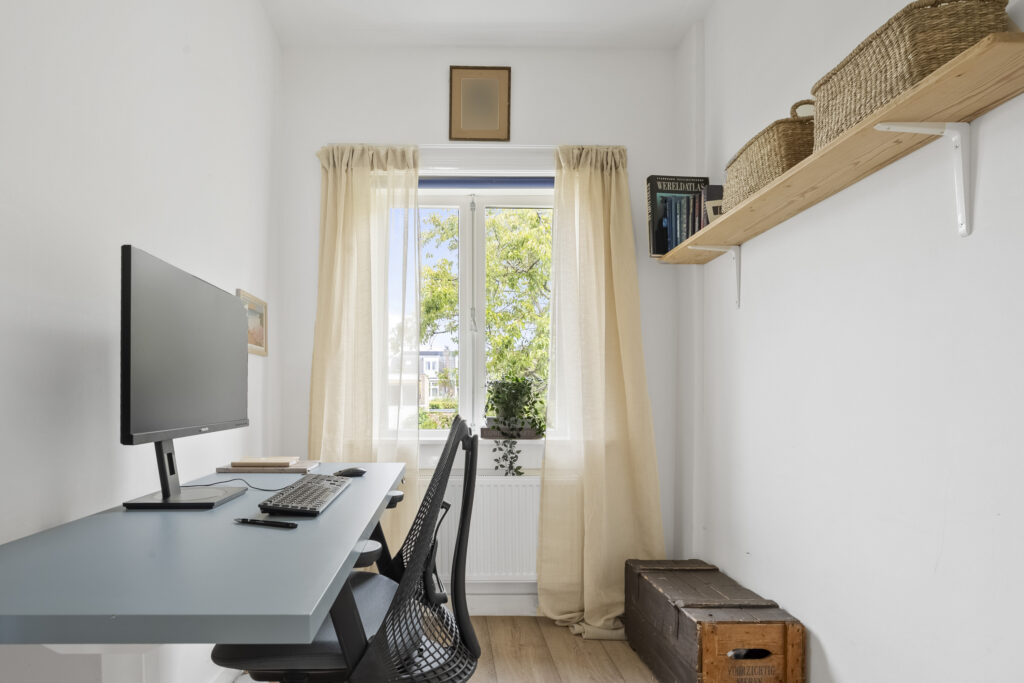 Minimalist home office with computer and natural light.