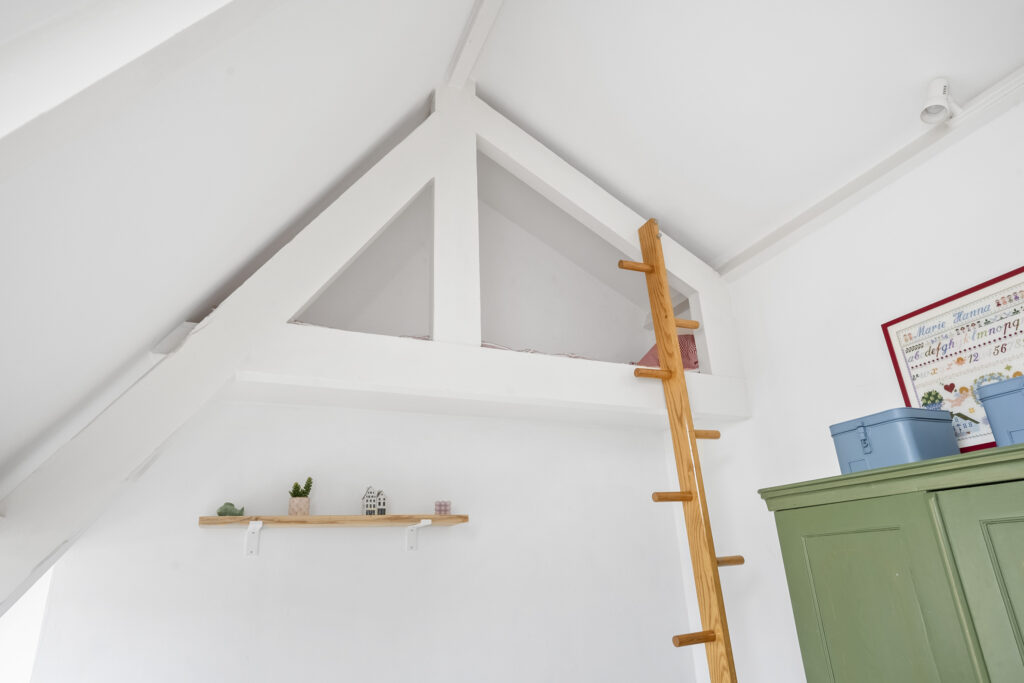 Loft with wooden ladder in bright room