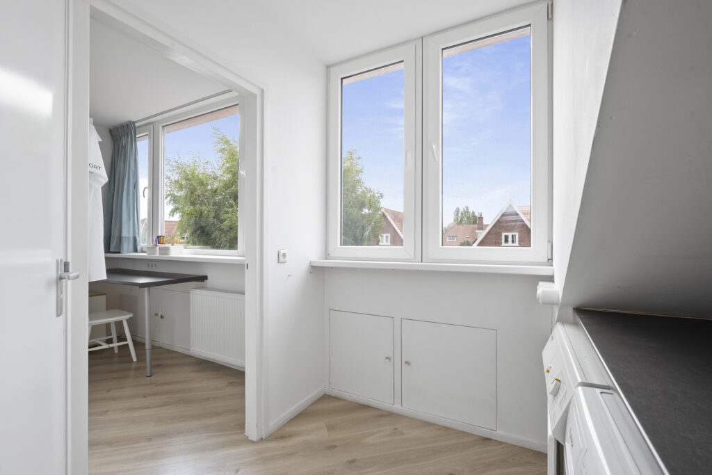 Bright room with wooden floor and large windows.