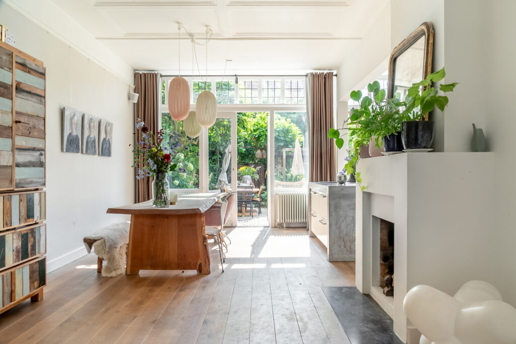 Bright dining room with wooden table and large windows.