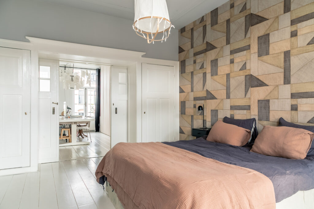 Modern bedroom with geometric accent wall and desk