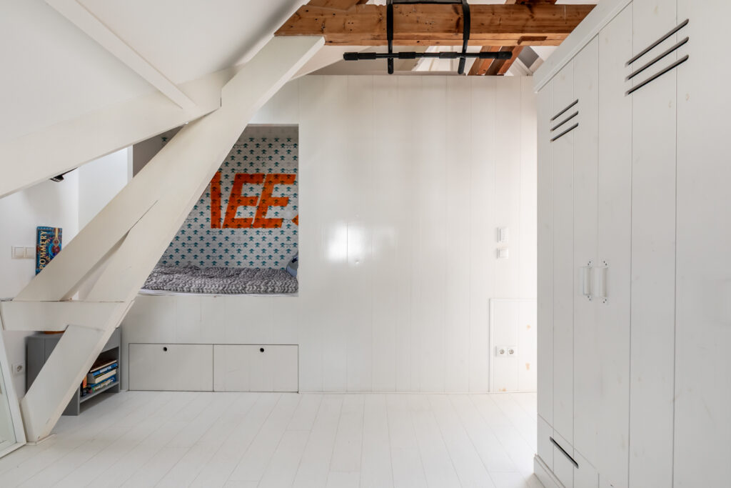 Modern bedroom with loft bed and white decor.