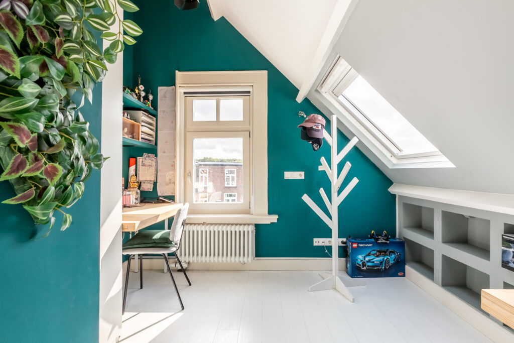 Cozy attic workspace with window and greenery.