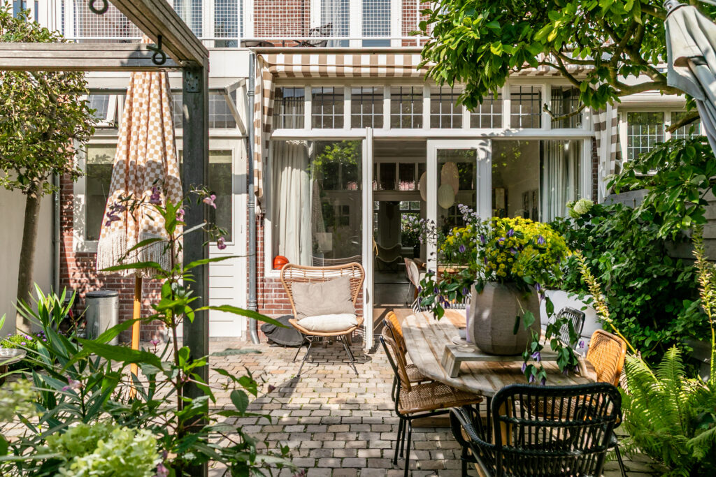 Sunny backyard with patio furniture and flowers.