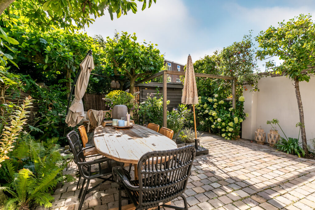 Cozy garden patio with dining table and chairs.