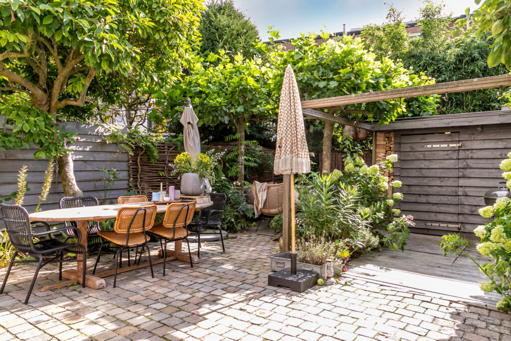 Cozy backyard garden with dining set and plants.