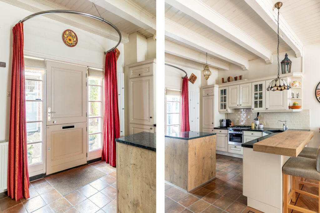 Cozy kitchen with island and red curtains.
