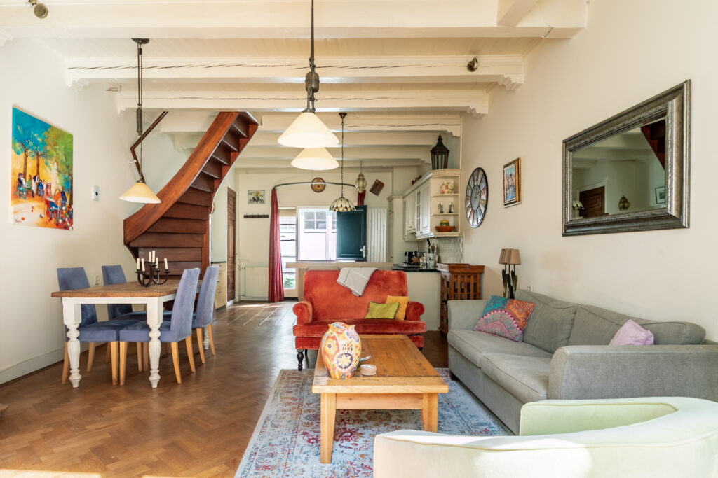 Cozy living room with colorful furniture and staircase.