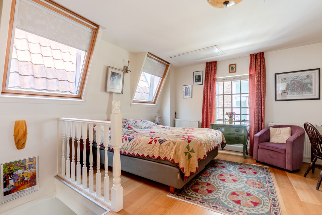 Cozy attic bedroom with quilt and skylights.