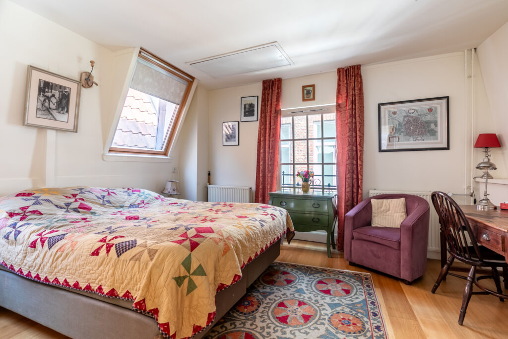 Cozy bedroom with quilted bedspread and vintage decor.