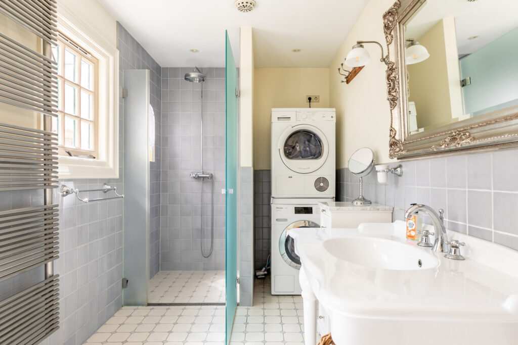 Modern bathroom with shower and laundry appliances