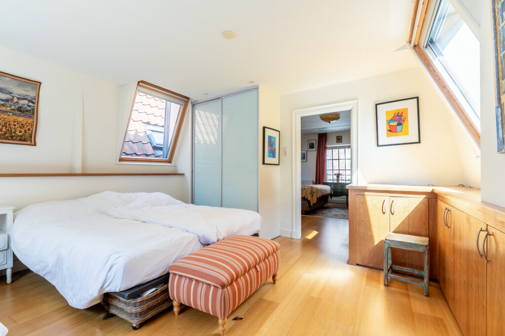 Cozy attic bedroom with skylight and wooden furniture.