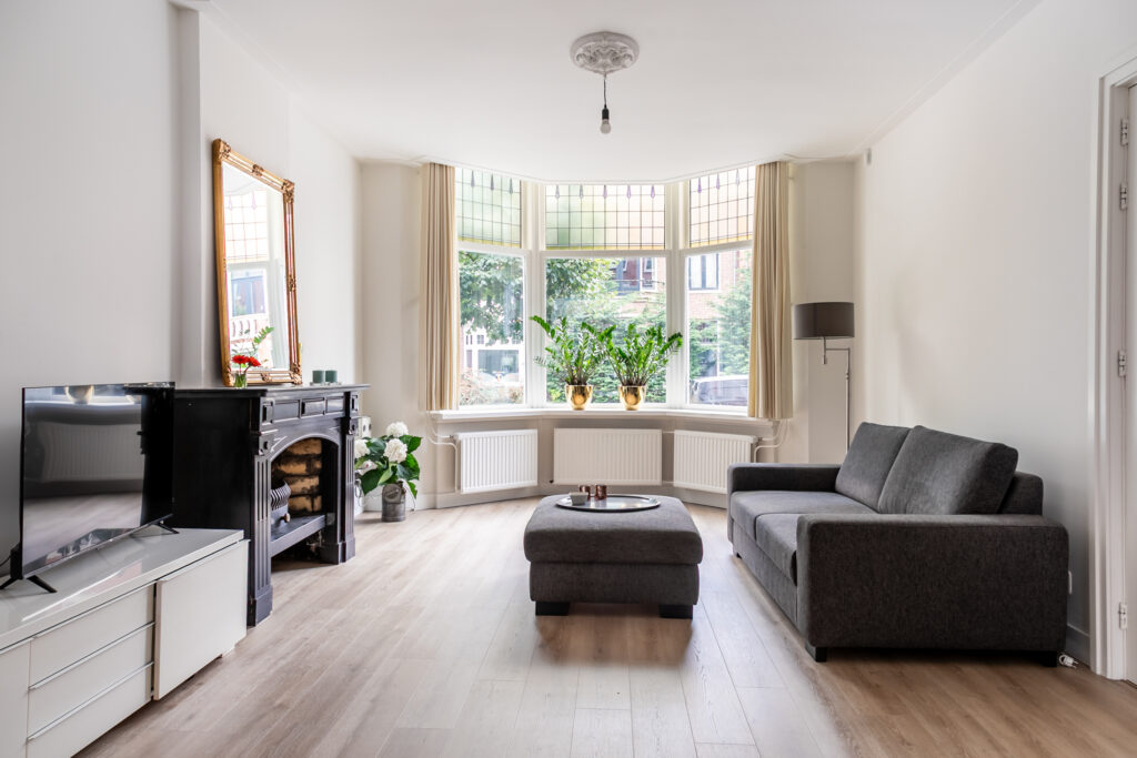 Spacious living room with modern decor and large window.