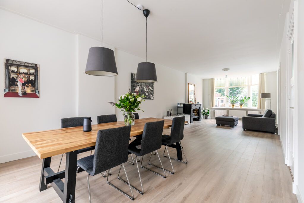 Modern dining and living room with plants and art.