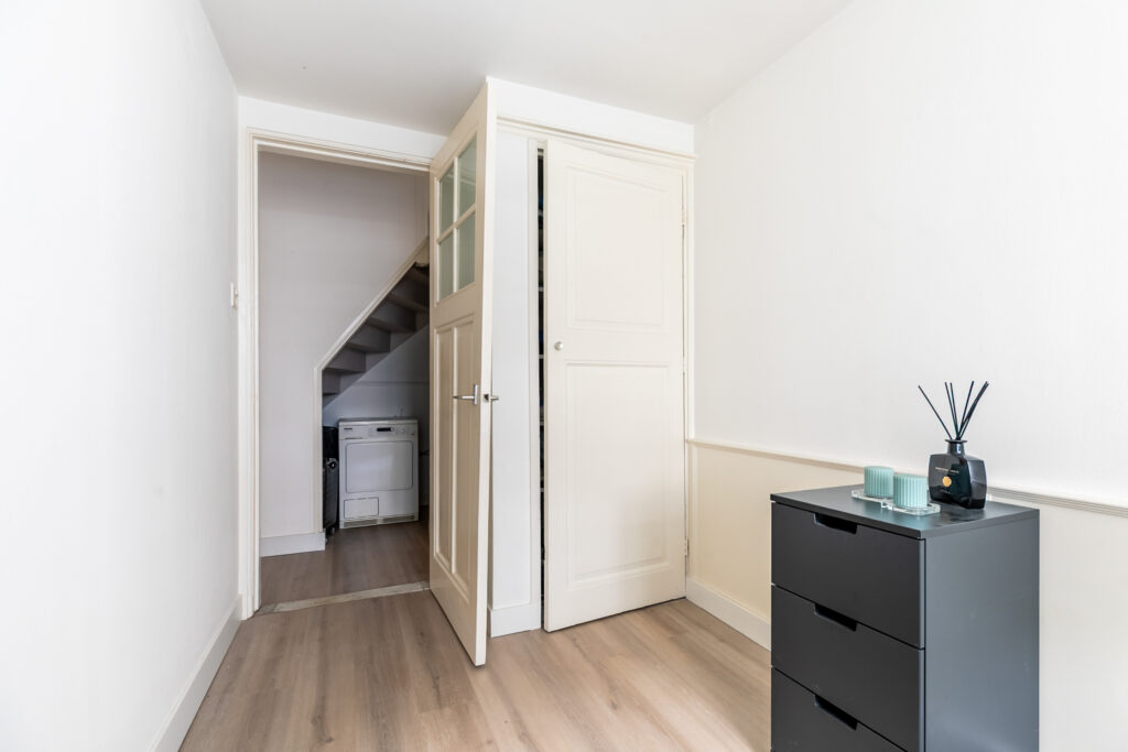 Small room with dresser and open laundry closet