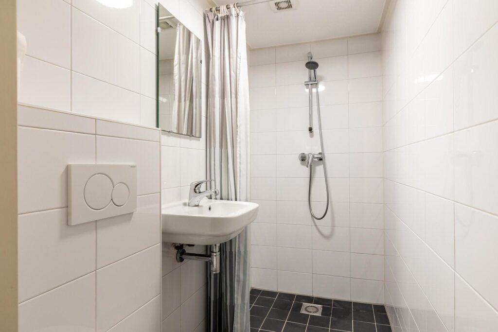 Modern white bathroom with shower and sink.
