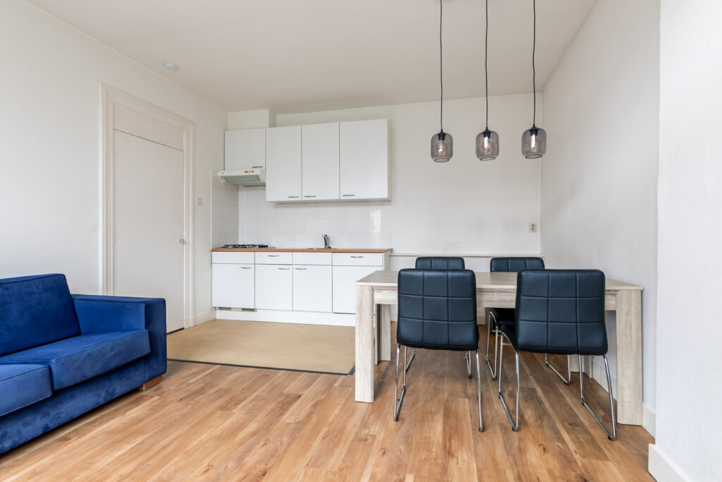 Modern kitchen and dining area with blue couch.