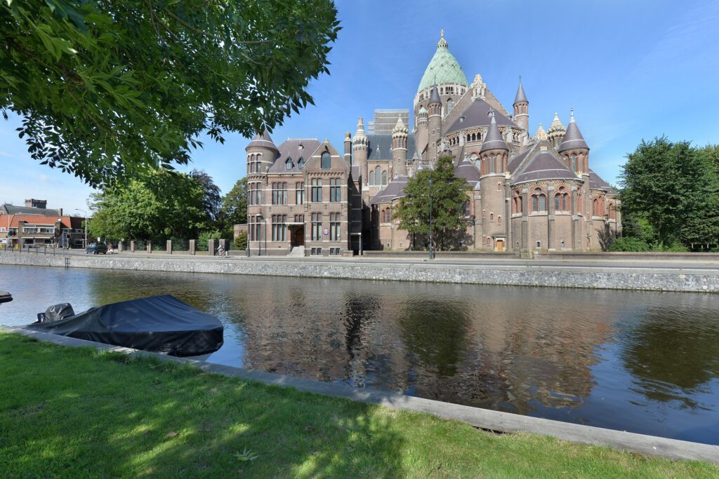 Historic brick church beside a riverside promenade.
