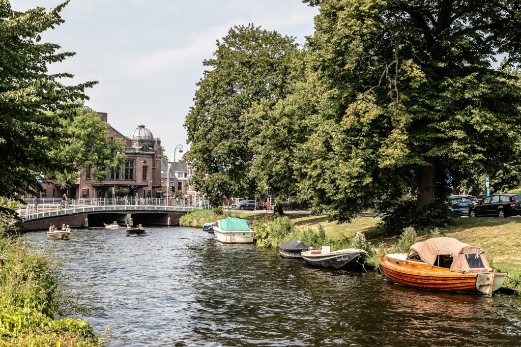 Scenic canal with boats and bridge in city.
