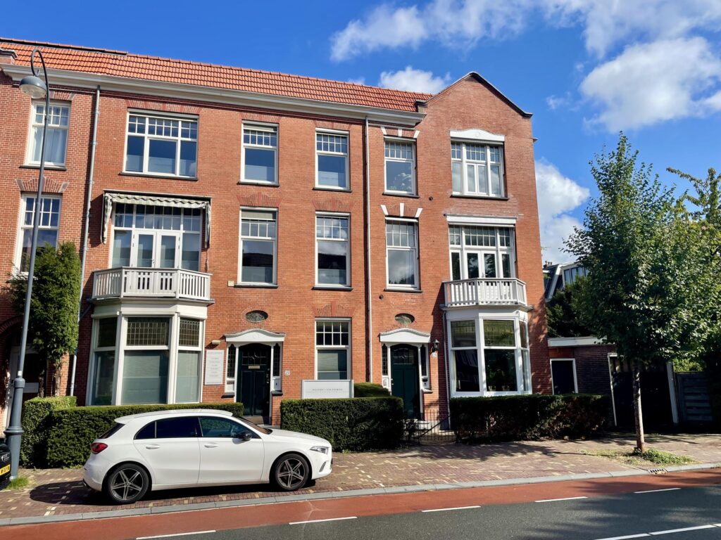Red brick building with car parked outside.