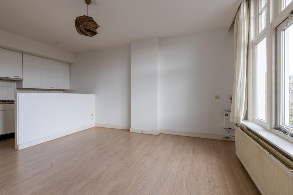 Empty room with white walls and wooden floor.