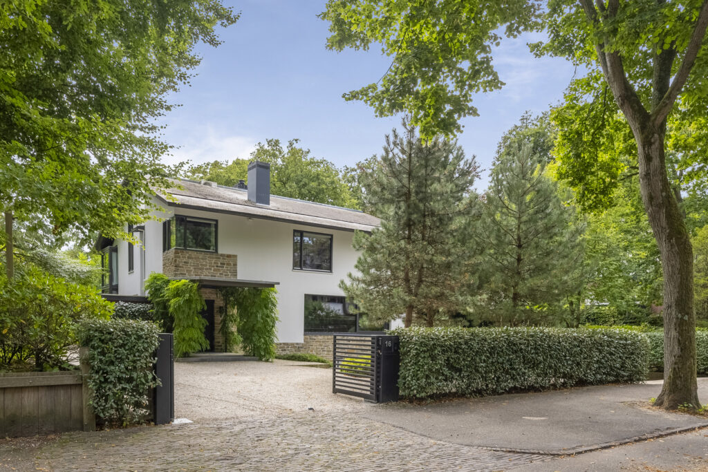 Modern two-story house surrounded by trees.