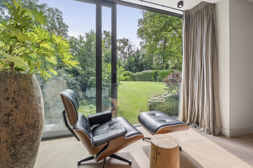 Modern lounge chair overlooking lush green garden