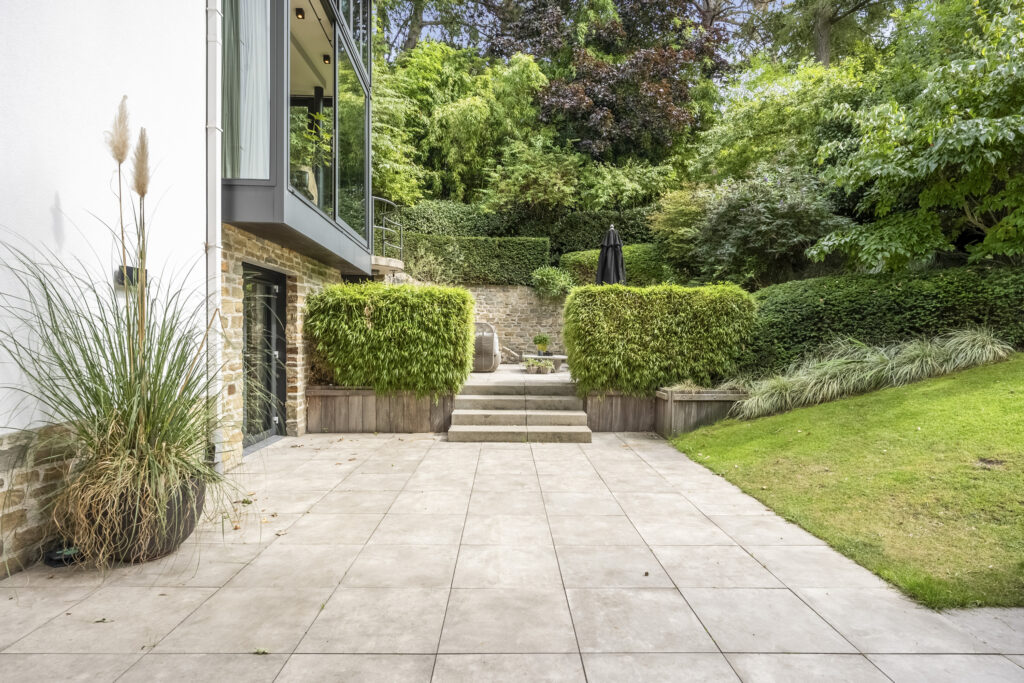 Modern patio with lush garden and stone steps