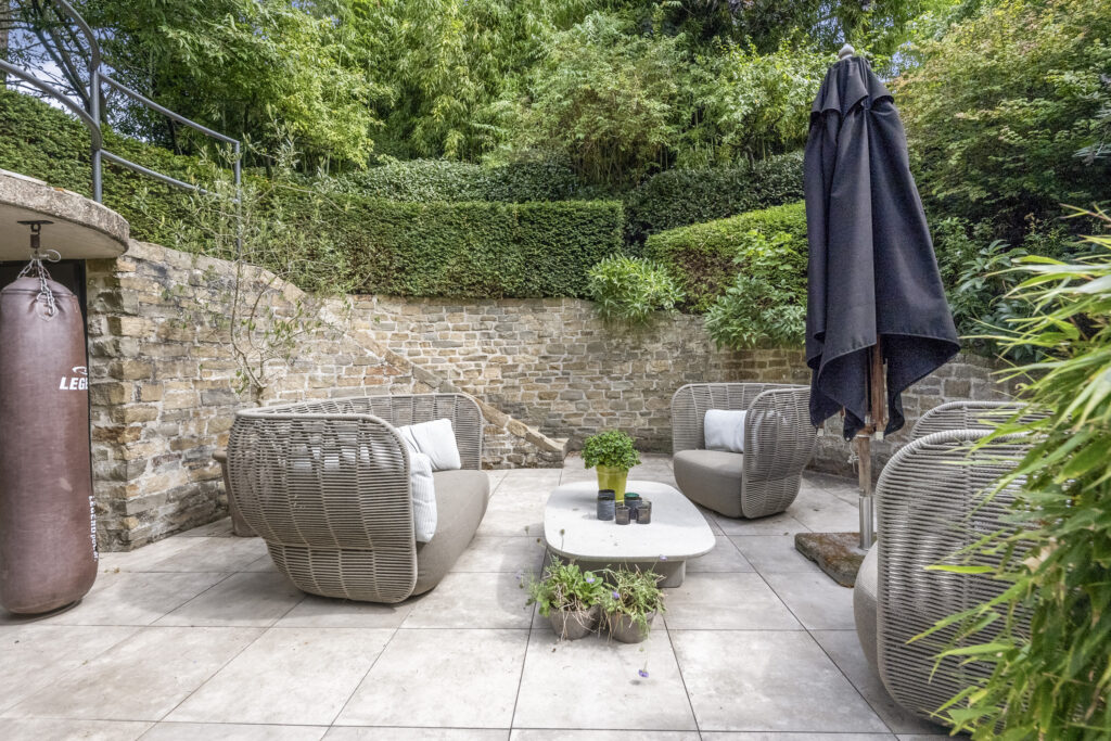 Outdoor patio with modern furniture and lush garden