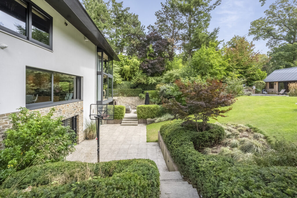 Modern house with lush garden and patio space.
