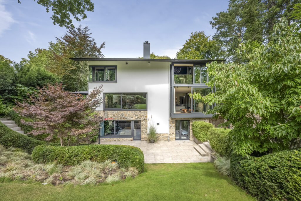 Modern house with large windows and garden.