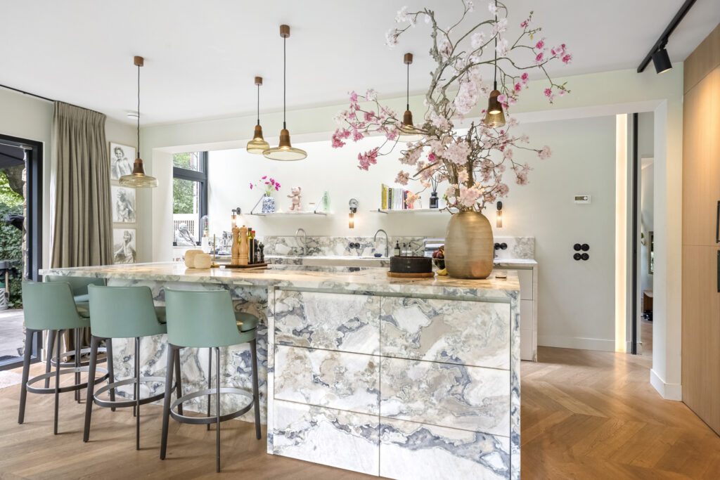 Modern kitchen with marble island and floral decoration.