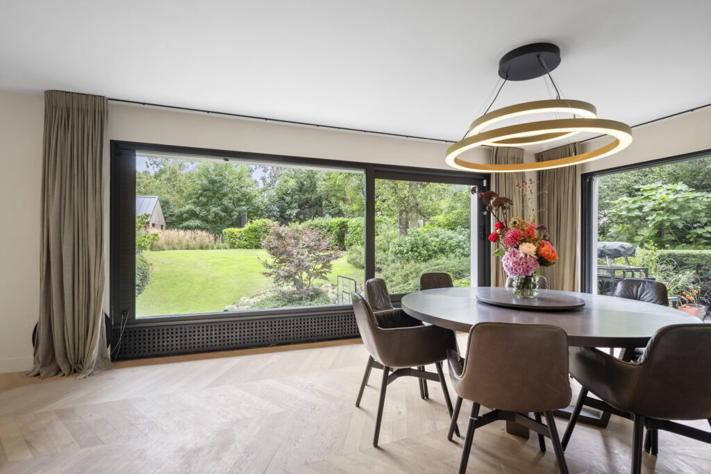 Dining room with garden view and modern chandelier.