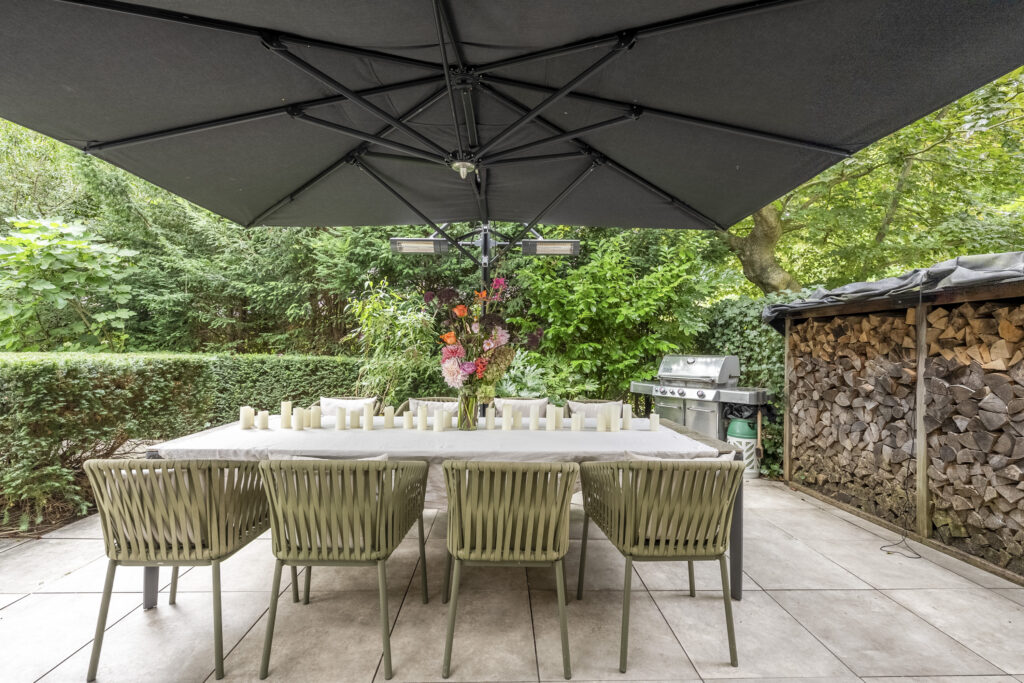 Outdoor dining setup with umbrella and wood storage