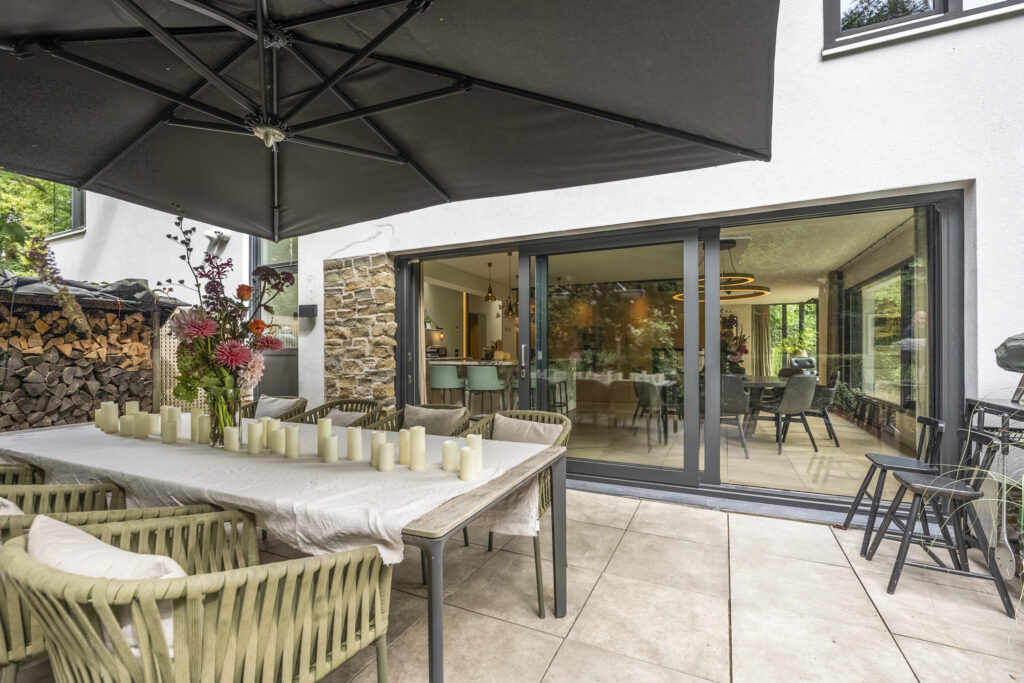 Modern patio with table, chairs, and candles.